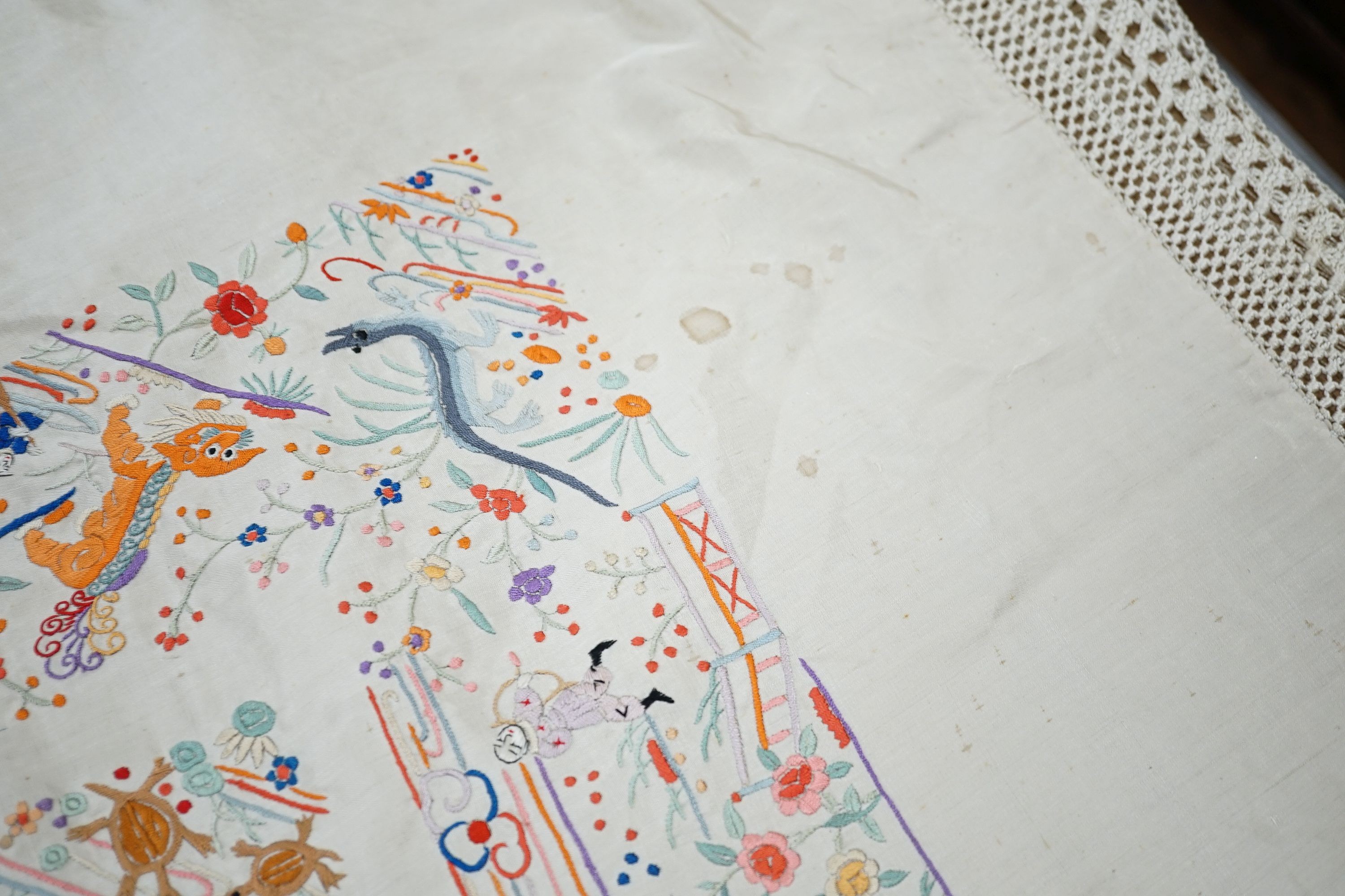 A Chinese cream silk shawl with fine multi coloured all over embroidery depicting figurative scenes and animals